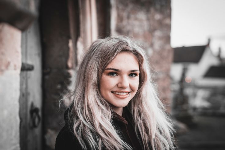 Girl with blonde hair and lip piercing smiling