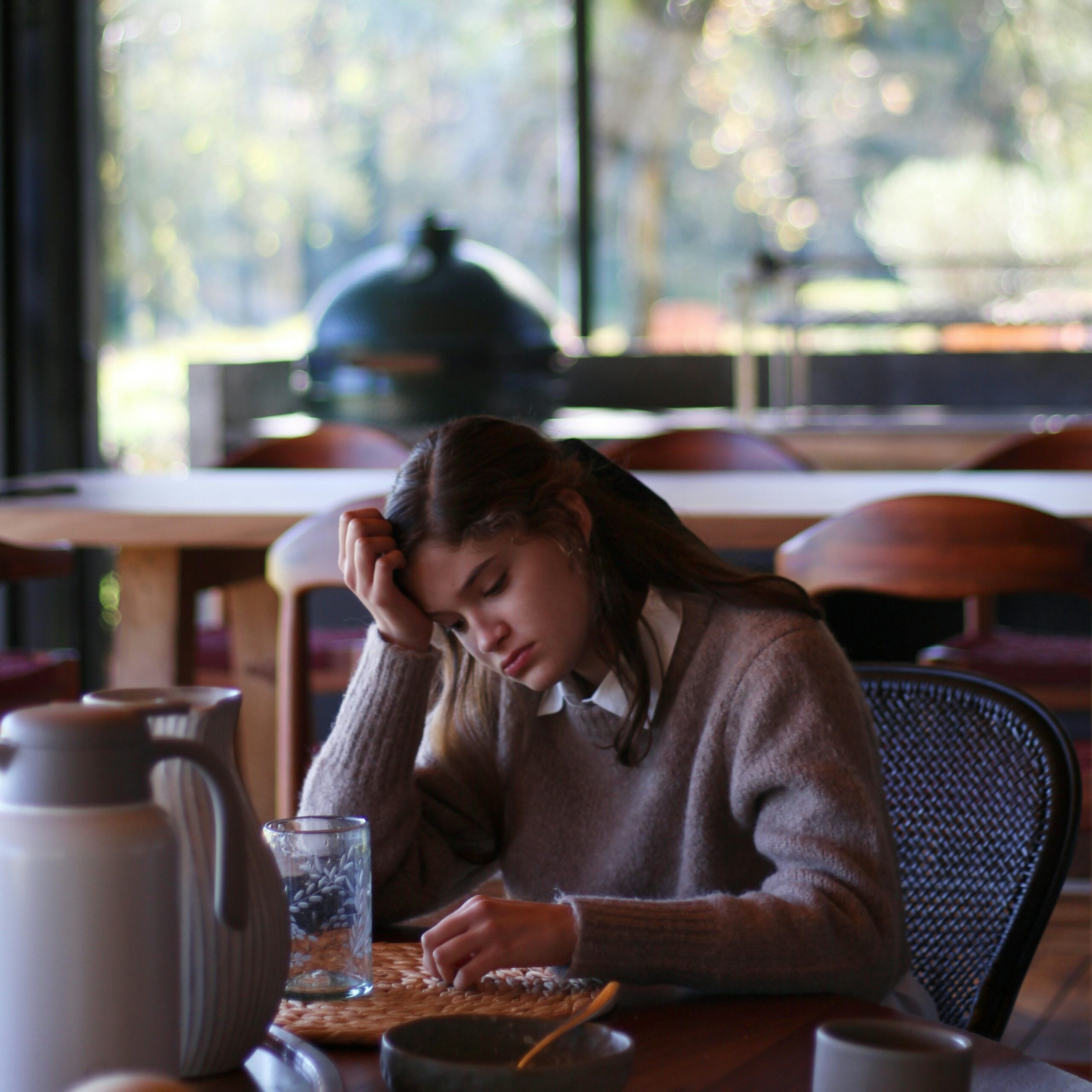 Girl sitting in cafe looking deep in thought