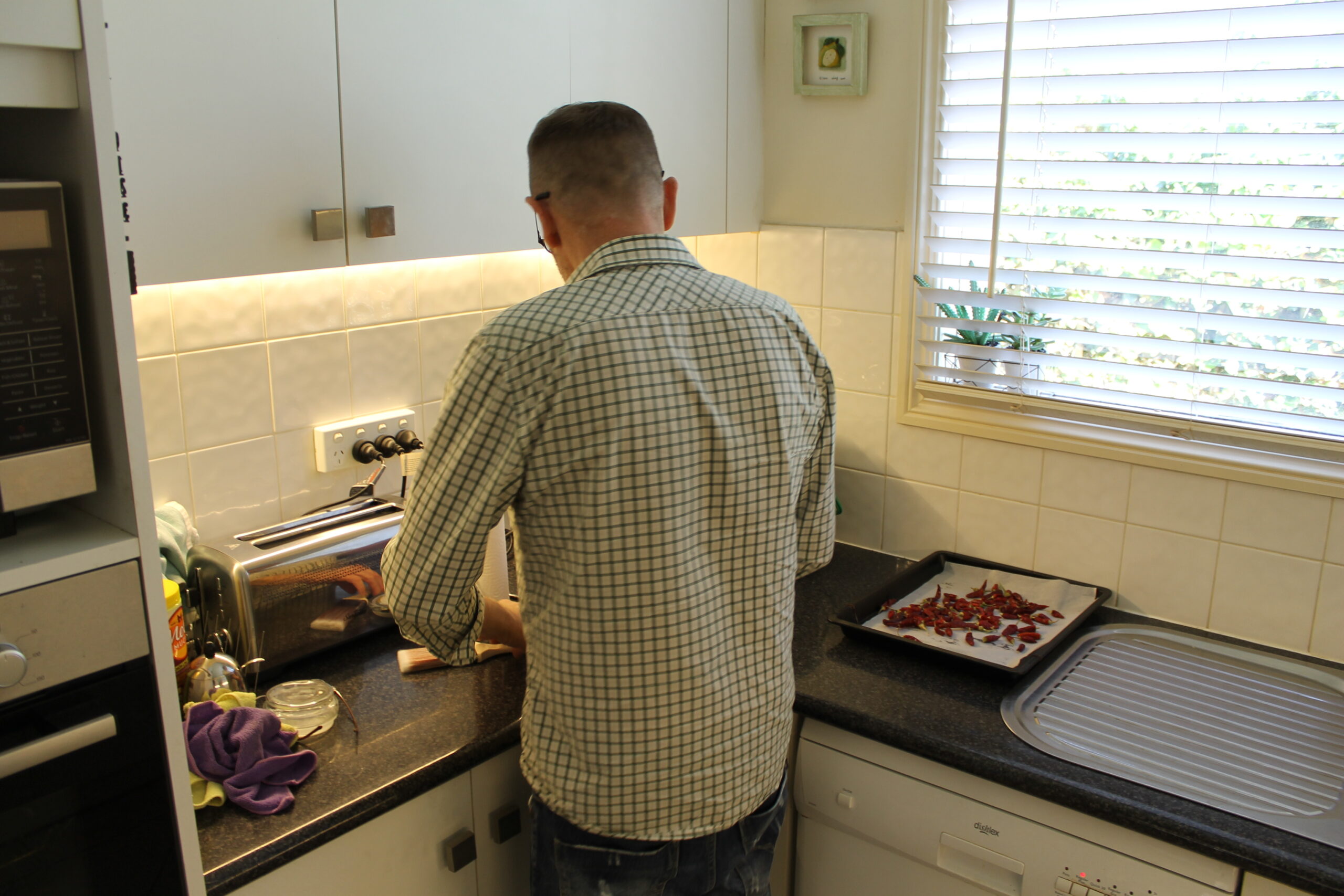 Luke stands in his kitchen cutting up food