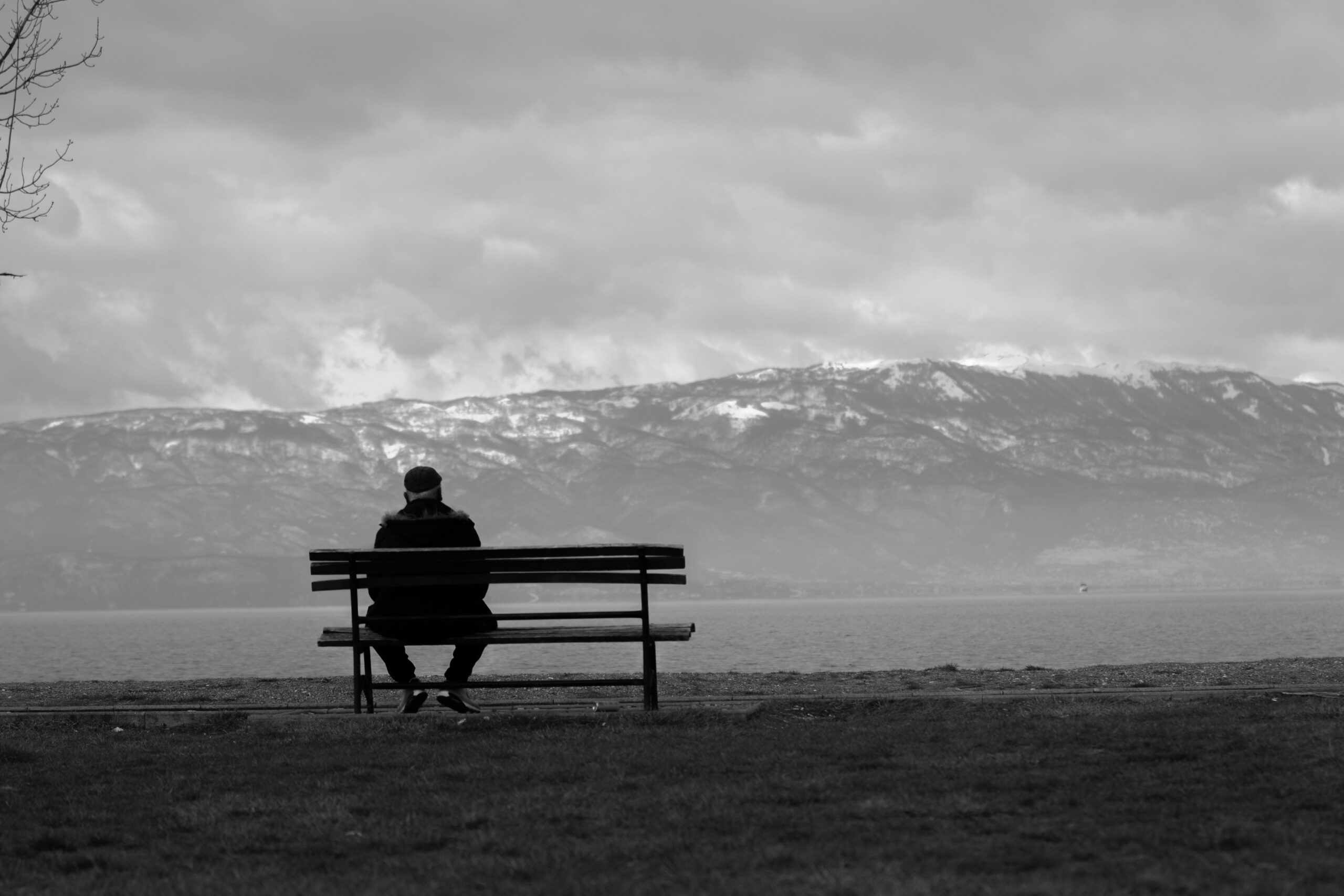 Solitary person sitting on outdoor bench