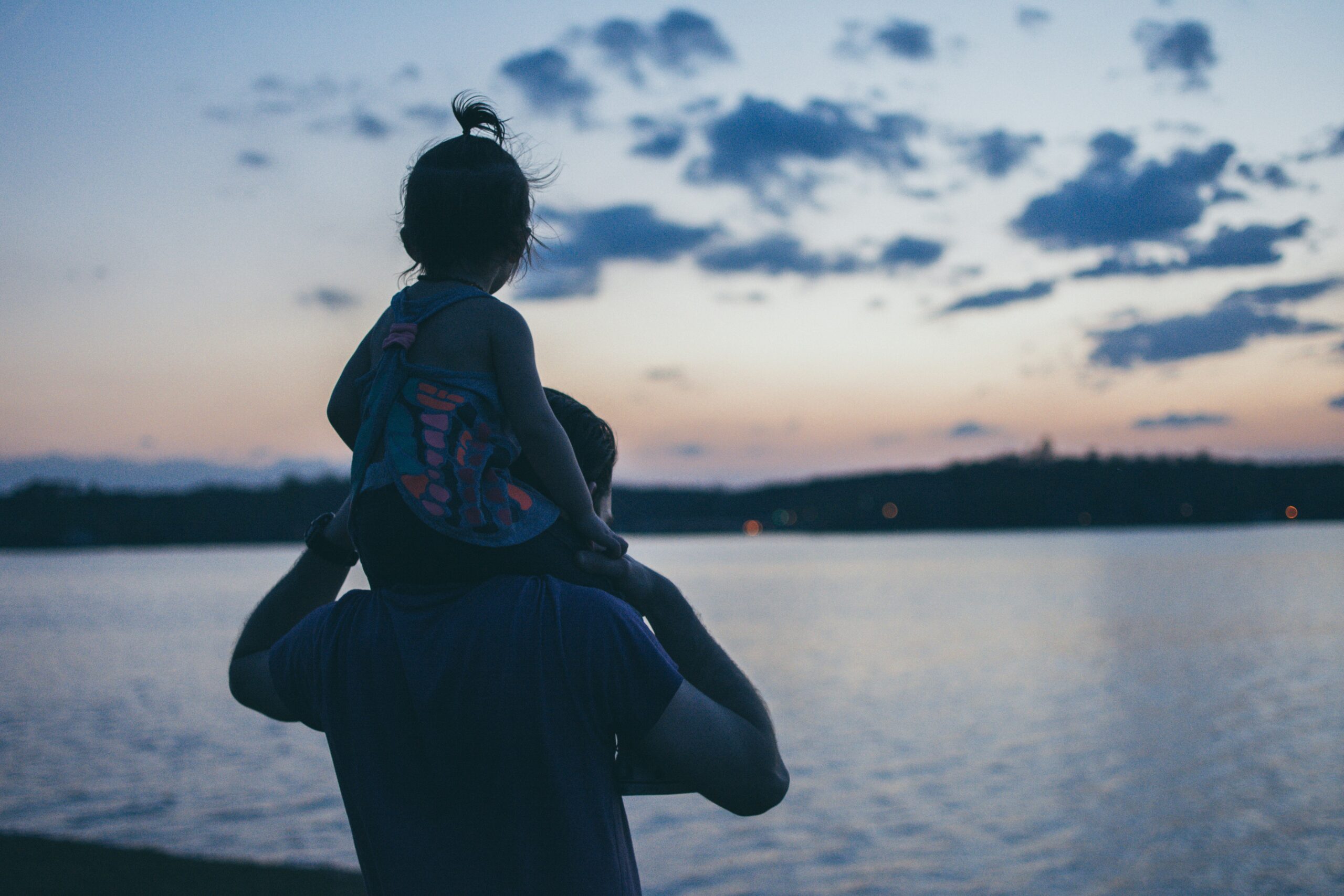 Child sitting on fathers' shoulders